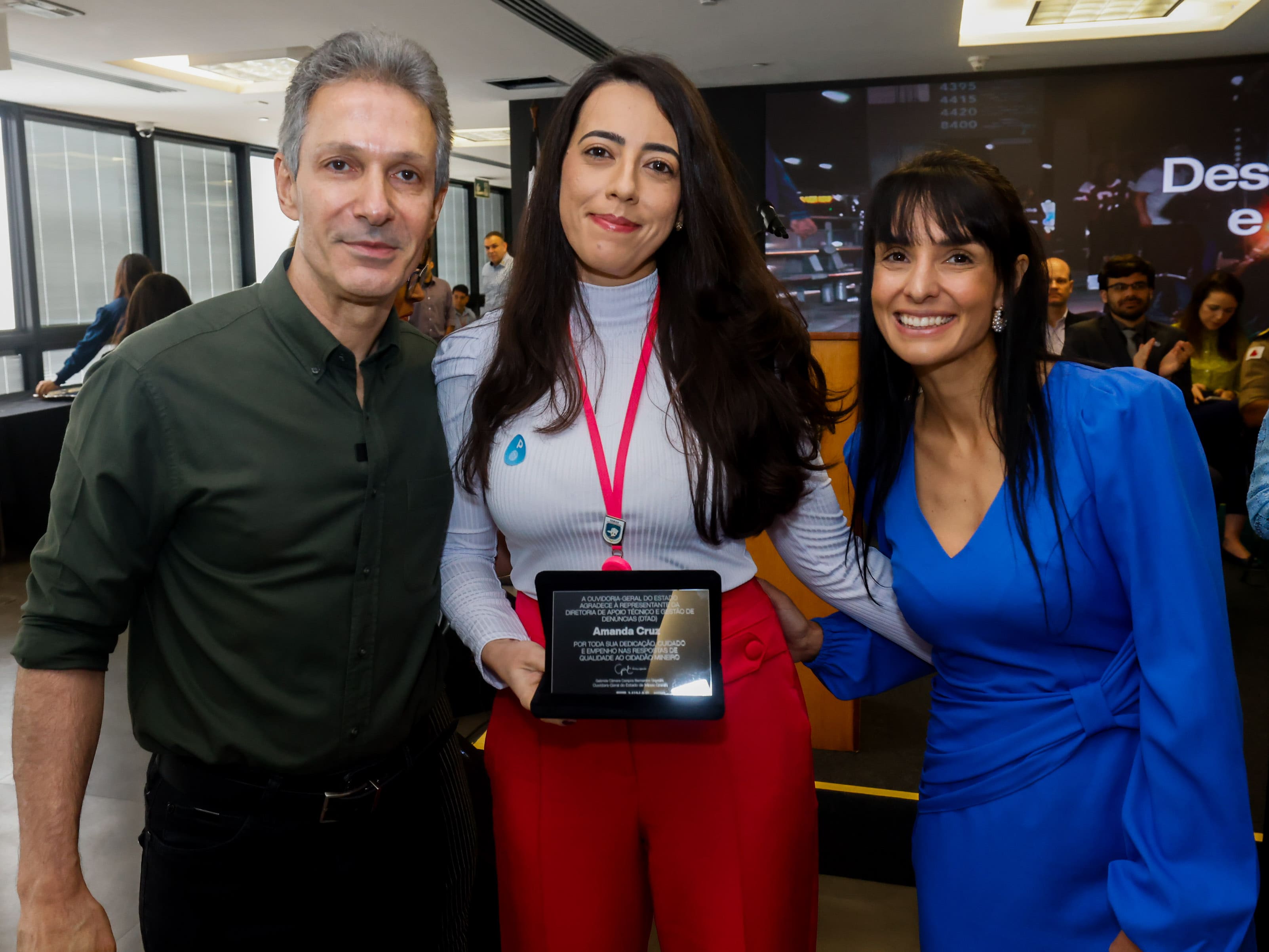 Amanda Cruz Parrela recebe homenagem no Prêmio Destaques da Ouvidoria e da Transparência, ao lado do governador Romeu Zema e da ouvidora-geral Gabriela Siqueira